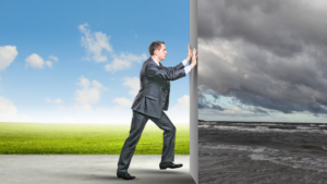 A man wearing a suit, intended to be a sales manager, pushing away a clouded grey setting to reveal a new, brighter setting with blue sky and green grass.